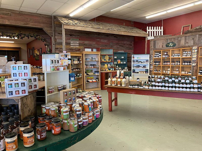 Display tables, shadow-boxes, and 1-sided fixtures with shelves displaying jars, bottles, and products.