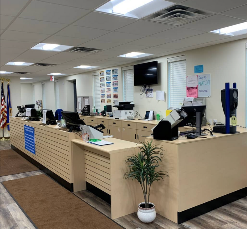 Office interior with a modular reception desk, chairs, and office equipment.