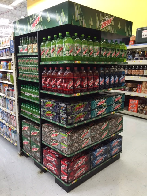 Mountain Dew End Cap display in a grocery store with various products on shelves.