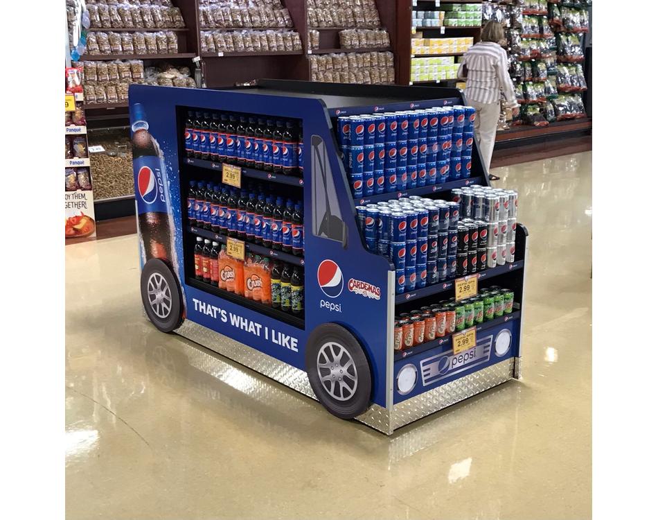 Pepsi display cart in a grocery store with various drinks.